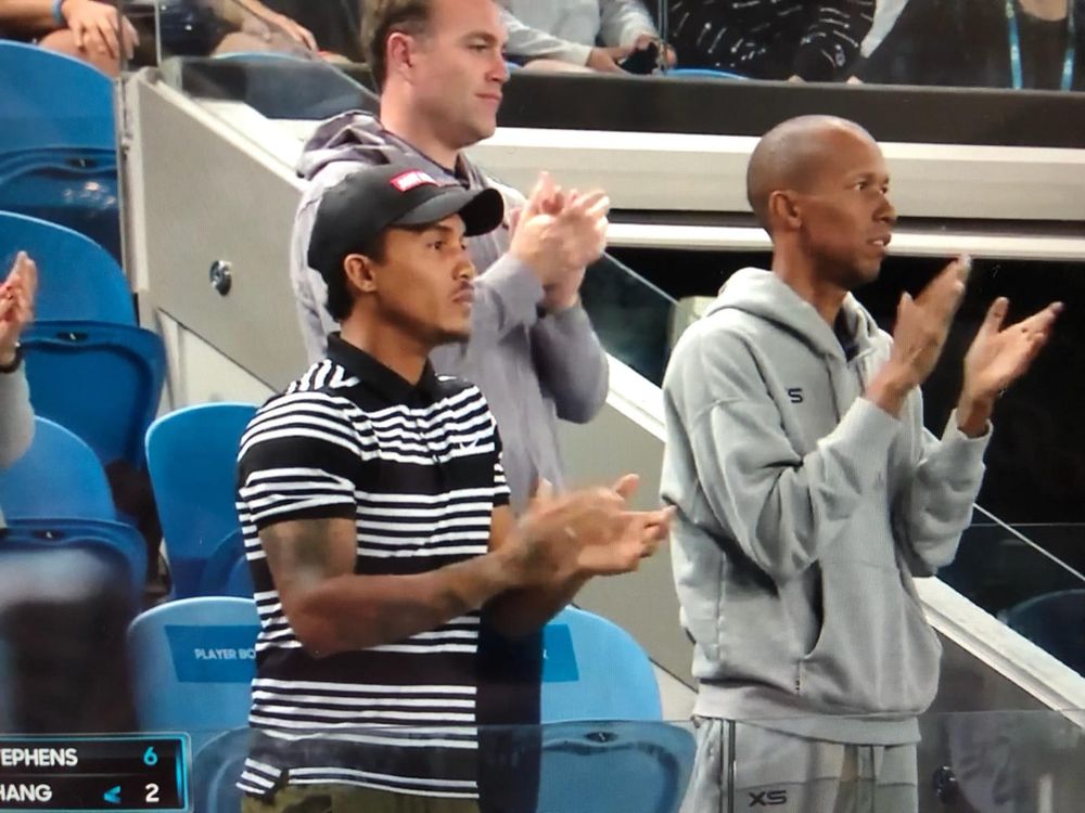 Coach Liam (front, striped shirt) applauding from Sloane Stephens’ player box at a pro tournament